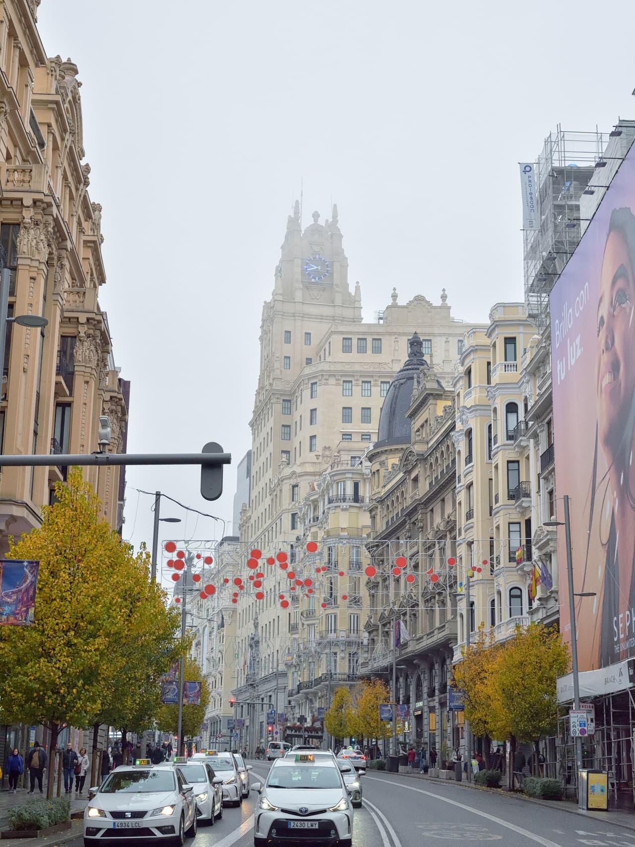 Looking up the length of Gran Vía in Madrid at night, with illuminated signs and traffic below.